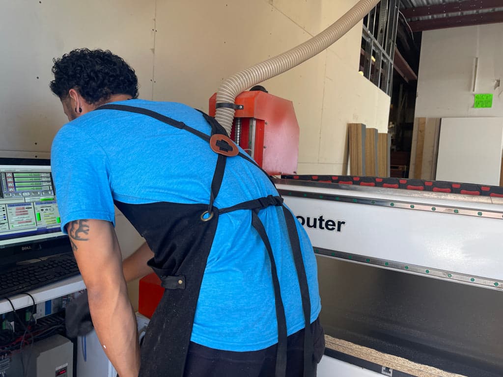 A Quality Arcades team member operating the CNC router